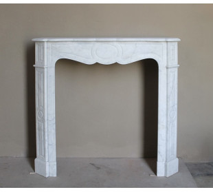 Caminetto antico Pompadour scolpito in marmo bianco dalle linee iconiche, d'un barocco leggero.