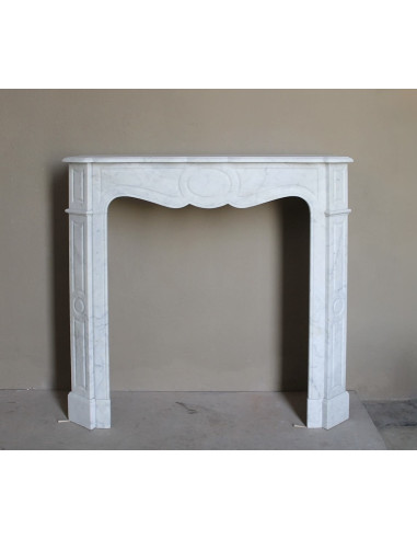 Caminetto antico Pompadour scolpito in marmo bianco dalle linee iconiche, d'un barocco leggero.