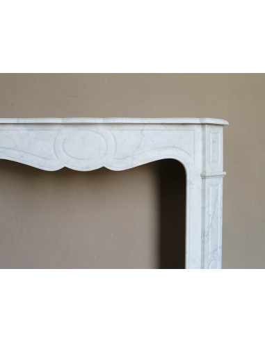 Caminetto antico Pompadour scolpito in marmo bianco dalle linee iconiche, d'un barocco leggero.