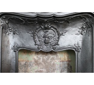 Caminetto antico Larcher in ghisa artistica con decori floreali. Al centro sta un "grenade", ovvero un melograno. 2