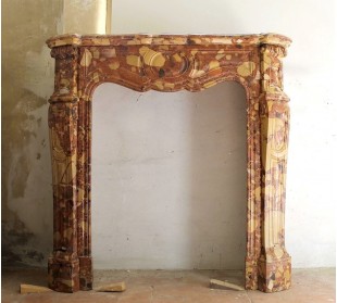 Piccolo e grazioso caminetto Pompadour Galbé scolpito in marmo variegatissimo, sui toni del giallo e del rosso.