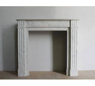 Caminetto neoclassico di piccole dimensioni scolpito in marmo bianco (grigio) di Carrara