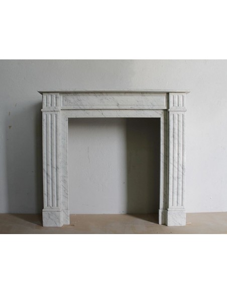 Caminetto neoclassico di piccole dimensioni scolpito in marmo bianco (grigio) di Carrara