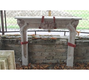 Cornice da camino di stile ed epoca Liberty, milanese, in graniglia di cemento, recante elementi decorativi floreali.